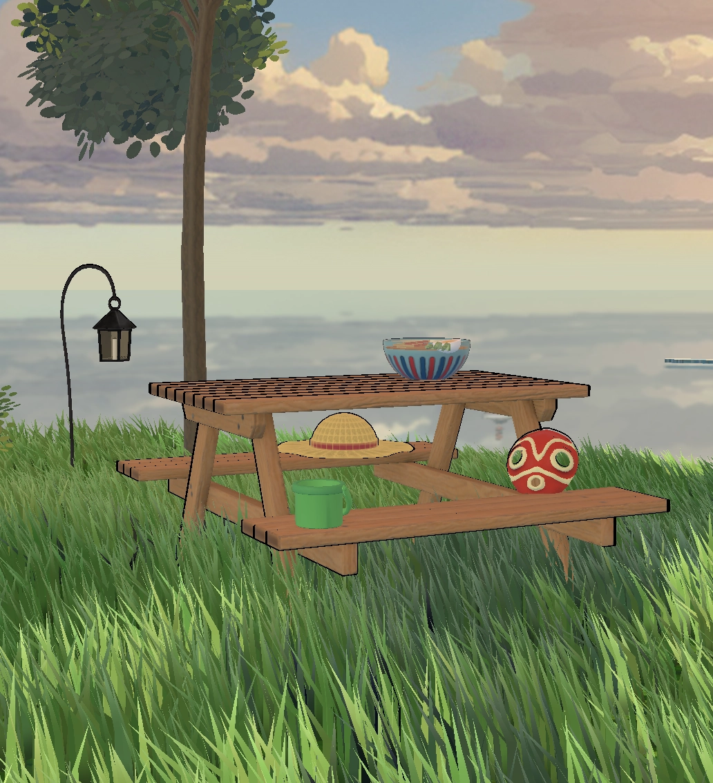 Close-up view of the picnic table in the grass, surrounded by references to Miyazaki films.